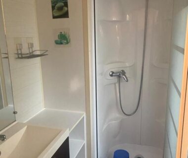 Salle de bain avec cabine de douche et lavabo dans le Mobilhome