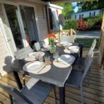 Terrasse en bois avec table dressée et chaises du Mobilhome 3 chambres TV-WIFI-Lave-linge