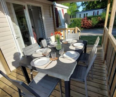 Terrasse en bois avec table dressée et chaises du Mobilhome 3 chambres TV-WIFI-Lave-linge