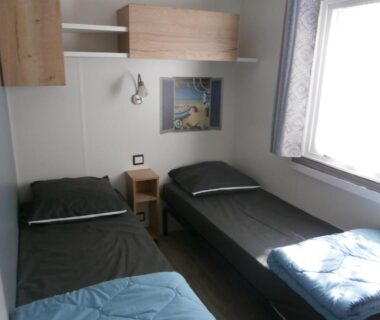 Intérieur chambre avec deux lits simples et fenêtre dans le Mobilhome 3 chambres tout confort proche de la plage