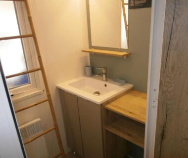 Salle d'eau avec lavabo miroir et étagères dans le Mobilhome 3 chambres tout confort proche de la plage