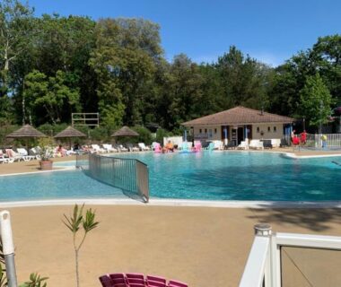 Bord de piscine avec transats et parasols au mobilhome 3 chambres tout confort proche de la plage