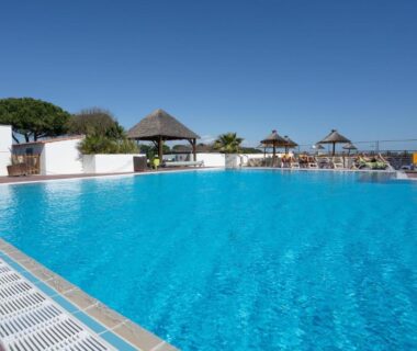 Piscine extérieure avec parasols et transats au Mobilhome 373