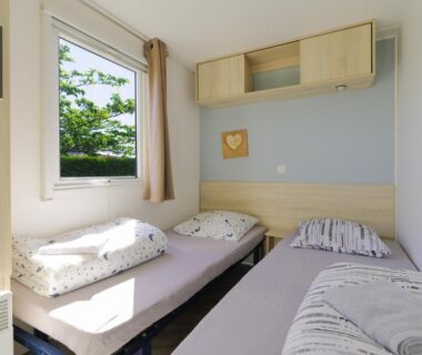 Chambre avec lits simples et fenêtre dans le mobilhome 373