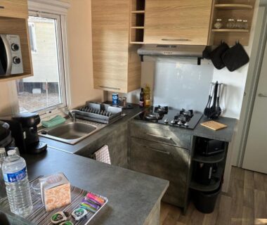 Intérieur avec cuisine équipée et plan de travail dans le mobilhome 379 du camping 4 étoiles Siblu Lattes