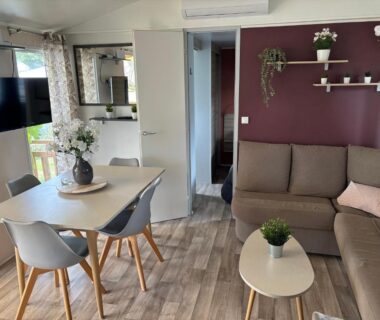 Séjour avec canapé et coin repas dans le mobilhome 379 camping 4 étoiles Siblu lattes