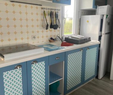 Cuisine équipée avec plan de travail et réfrigérateur dans le Mobilhome