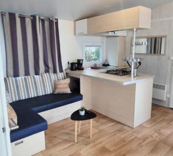 Salon avec kitchenette et coin repas dans le Mobilhome