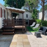 Terrasse ombragée sous auvent avec salon de jardin et chaises longues du mobilhome 4 CA61