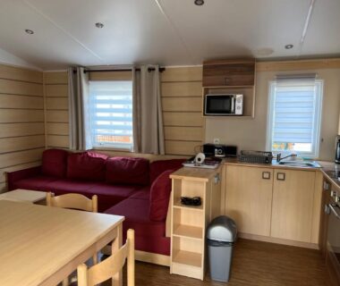 Salon avec canapé et kitchenette dans le Mobilhome 4 CA61