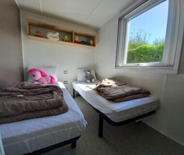Chambre avec deux lits simples et fenêtre dans le Mobilhome 4 pers 2 ch Centre Aquatique