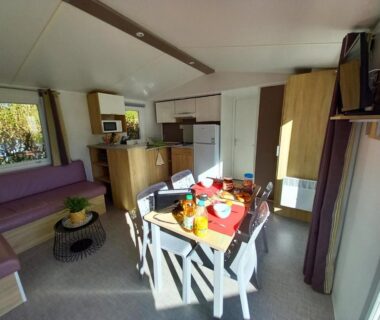 Intérieur avec table à manger et kitchenette du Mobilhome 4 pers – 2 ch – Centre Aquatique