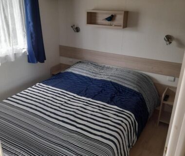 Chambre avec lit double et chevets près de la fenêtre dans le mobilhome 4 personnes