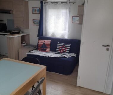 Salon avec canapé et coin repas dans le Mobilhome 4 personnes