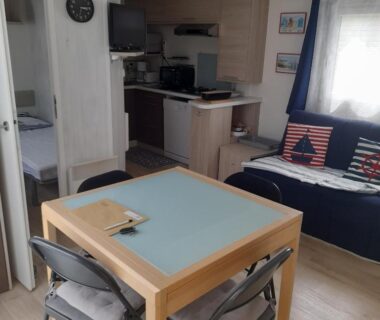 Intérieur avec table chaises et kitchenette dans le Mobilhome 4 personnes