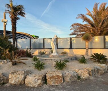 Entrée paysagée avec statue et palmiers au Mobilhome 400m de la plage Camping 5 étoiles