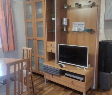 Séjour avec meuble TV table à manger et chaises dans le Mobilhome