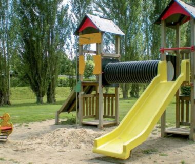Aire de jeux avec toboggan en bois et bac à sable au Mobilhome