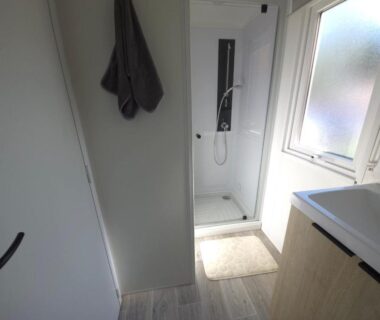 Salle d'eau avec cabine de douche lavabo et fenêtre dans le Mobilhome 5 PLACES