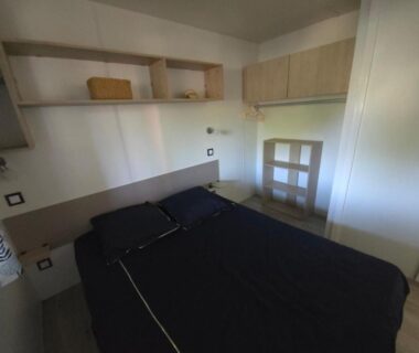 Chambre avec lit double étagères et placard dans le Mobilhome 5 PLACES