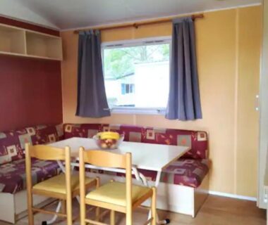 Coin repas intérieur avec banquette et table dans le Mobilhome 5 place proche mer