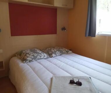 Intérieur de la chambre avec lit double et fenêtre du Mobilhome 5 place proche mer
