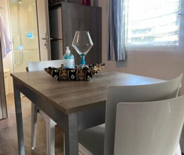 Coin repas avec table chaises et verre dans le Mobilhome 516