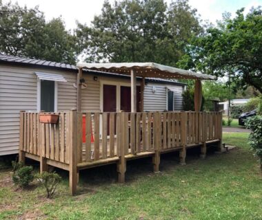 Terrasse en bois ombragée sur pelouse dans les Landes du Mobilhome