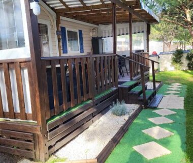 Terrasse en bois avec allée de dalles et pelouse dans les Landes Mobilhome