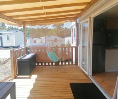 Terrasse en bois avec fauteuil suspendu et baie vitrée du mobilhome 6-8 pers Cap Ferret