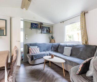 Salon avec canapé d'angle et table basse dans le mobilhome 6-8 personnes Cap Ferret