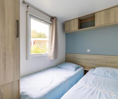 Chambre avec deux lits jumeaux rangement et fenêtre dans le Mobilhome 6-8 personnes Cap Ferret