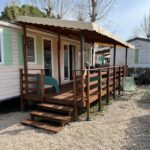 Terrasse couverte en bois avec chaises et transats du Mobilhome 6 CA36