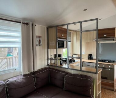 Séjour avec canapé et cuisine ouverte dans le Mobilhome 6 CA36