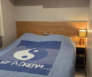 Chambre avec lit chevet et rangement dans le Mobilhome 6 à 7 personnes