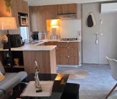 Intérieur avec canapé table et kitchenette dans le mobilhome 6 à 7 personnes