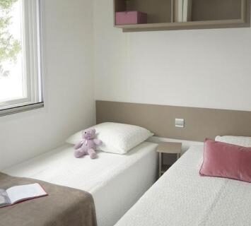 Intérieur avec deux lits jumeaux dans le Mobilhome 6 et 4 places terrasses couvertes Les Dunes de Contis