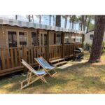 Terrasse en bois avec chaises longues et arbres du mobilhome 6 et 4 places terrasses couvertes Les Dunes de Contis