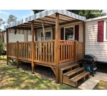 Terrasse couverte en bois avec salon et barbecue au Mobilhome 6 et 4 places Les Dunes de Contis