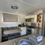 Intérieur avec cuisine, évier et banquette dans le mobilhome 6 pers 3 ch terrasse Domaine de Kerlann