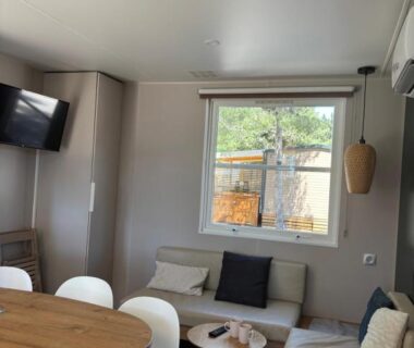 Séjour avec canapé et coin repas du Mobilhome 6 pers sous les pins