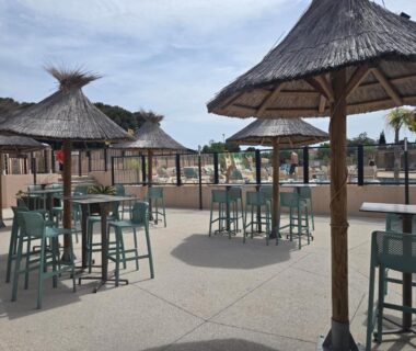 Terrasse extérieure avec parasols et tables au Mobilhome 6 pers 3ch 2SB 2 WC clim lave-vaisselle barbecue sous les pins