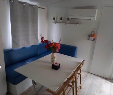 Coin repas avec banquette bleue et climatisation dans le Mobilhome 6 pers avec Clim