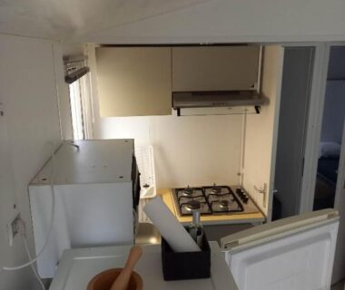 Cuisine intérieure avec plaque gaz hotte et mortier dans le Mobilhome 6 pers avec Clim