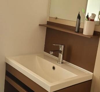 Salle de bain avec lavabo et miroir dans le mobilhome 6 personnes du camping Les Vignes