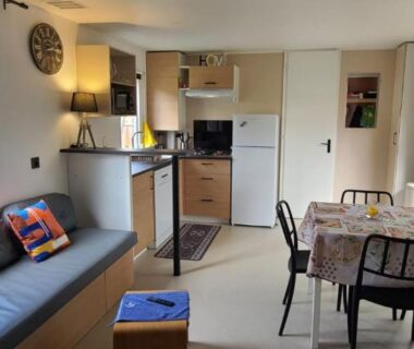 Séjour avec canapé, cuisine et table à manger dans le mobilhome 6 personnes au camping Les Vignes