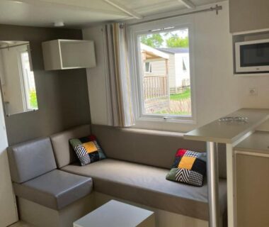 Salon avec canapé table et kitchenette dans le mobilhome 6 personnes