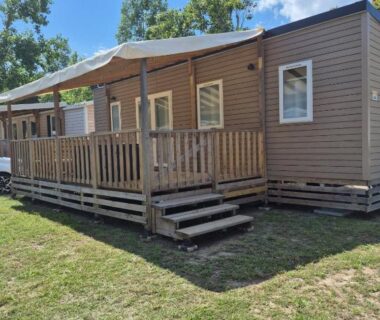 Terrasse en bois et pelouse devant l'hébergement Mobilhome 6 personnes domaine de la yole