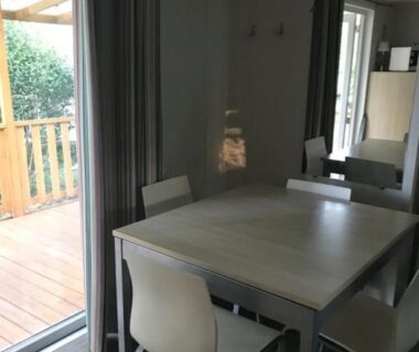 Intérieur coin repas avec table et chaises dans le Mobilhome 6 place aureilhan