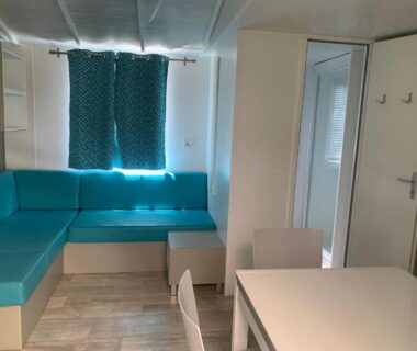 Intérieur salon avec banquette et table du mobilhome 6 personnes au Camping le Neptune Argelès-sur-Mer